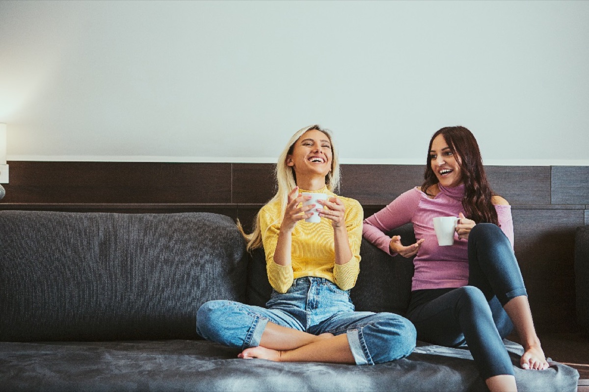 Two friends relaxing on the sofa in their rented home